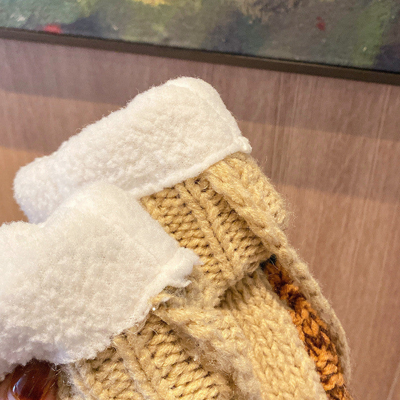Close-up of a textured fabric with white and beige patterns, possibly a sweater or coat lining.
