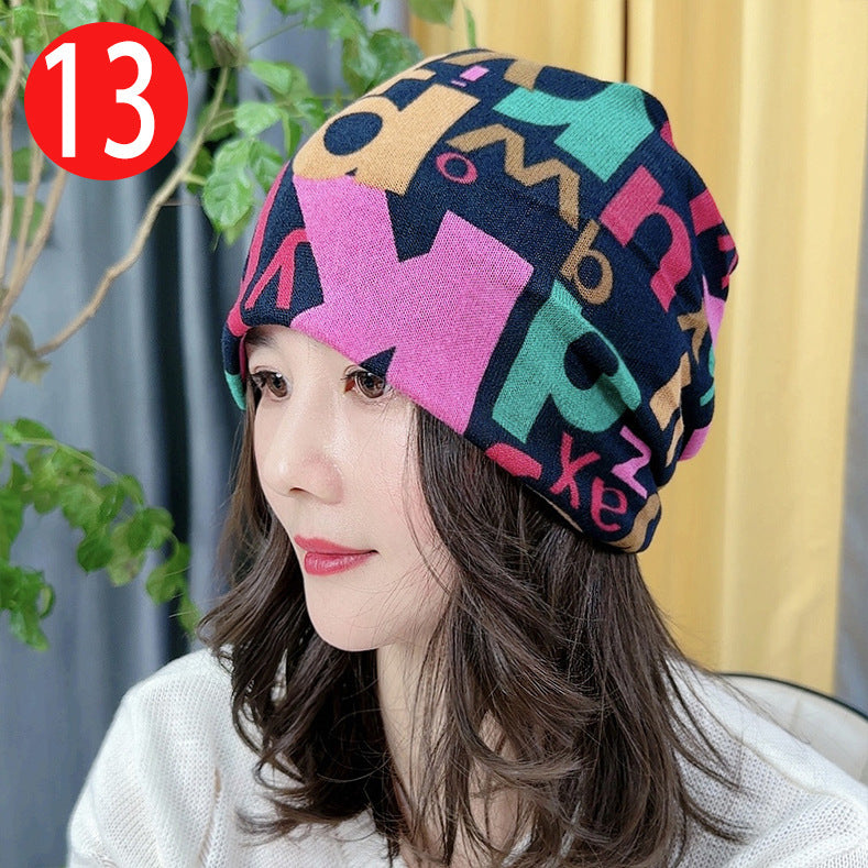 Woman wearing a colorful patterned beanie with a plant and yellow curtain in the background