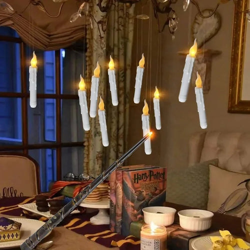 Decorative setup with candles and a wand on a table, featuring a 'Harry Potter' book.