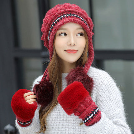 Person wearing a red knitted hat and gloves with a white background