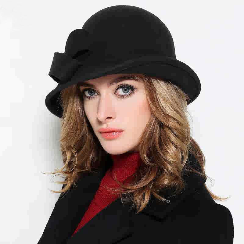 Woman wearing a black hat with a bow on a white background