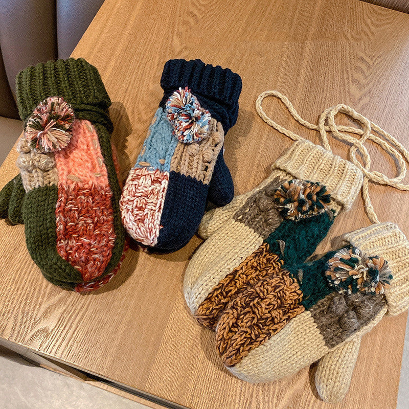 Colorful knitted mittens with decorative elements on a wooden surface