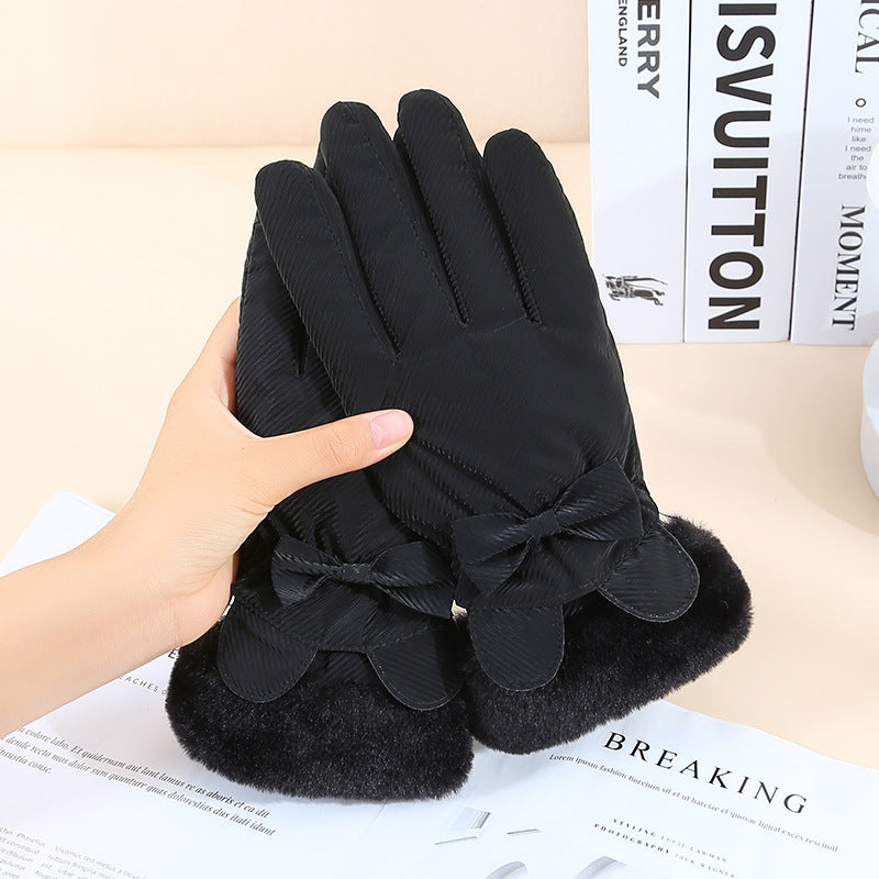 Black gloves with fur cuffs held by a hand on top of a magazine