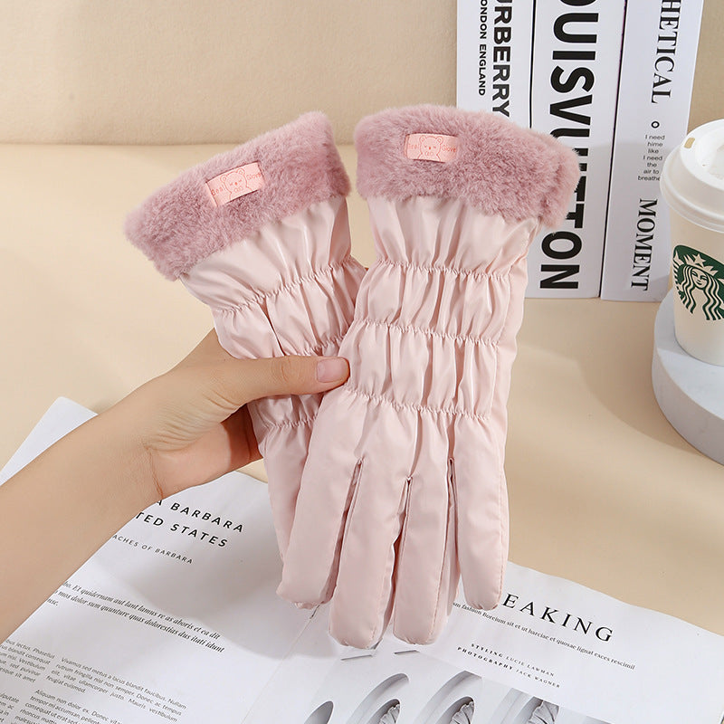 Pink gloves with fluffy cuffs held over a magazine and Starbucks cup