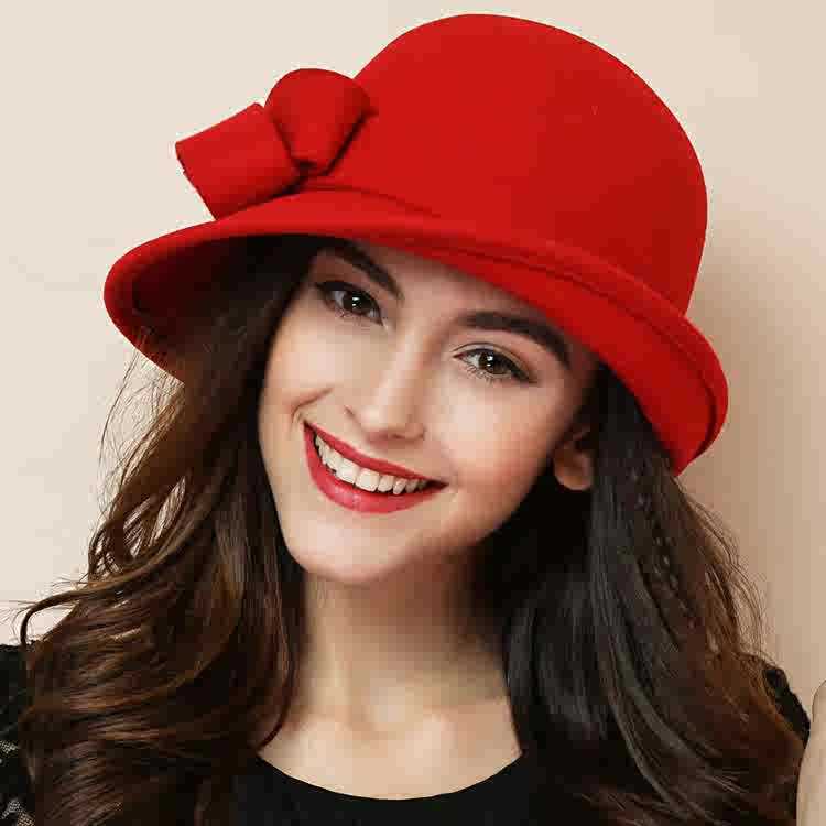 Woman wearing a red hat with a bow on a beige background