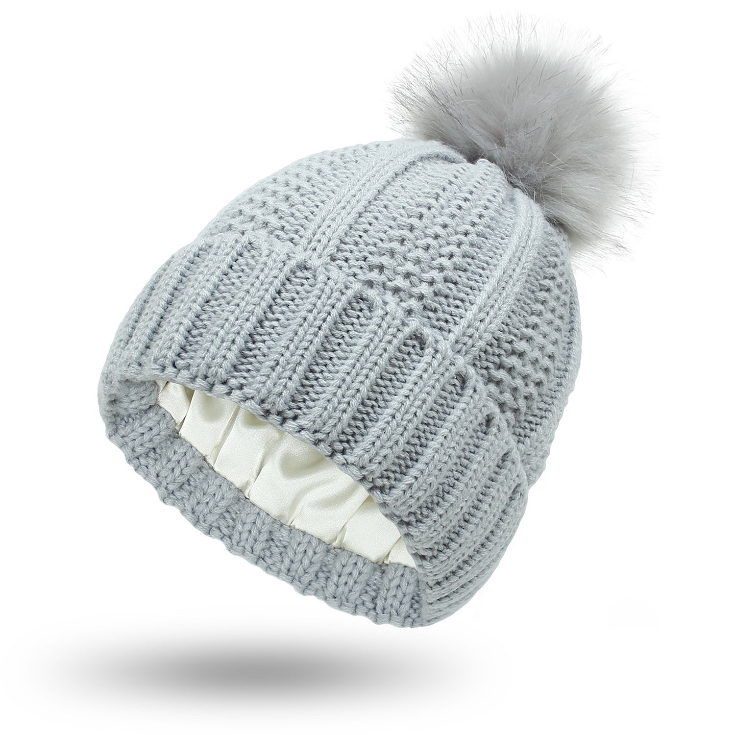 Knitted beanie with a fur pom-pom on a white background