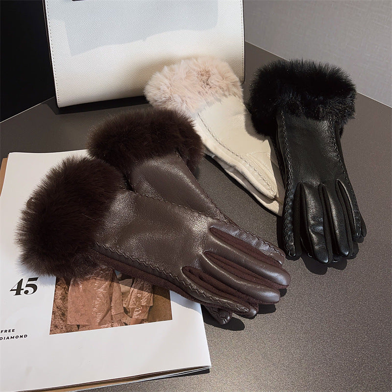 Pair of dark brown leather gloves with fur cuffs on a magazine