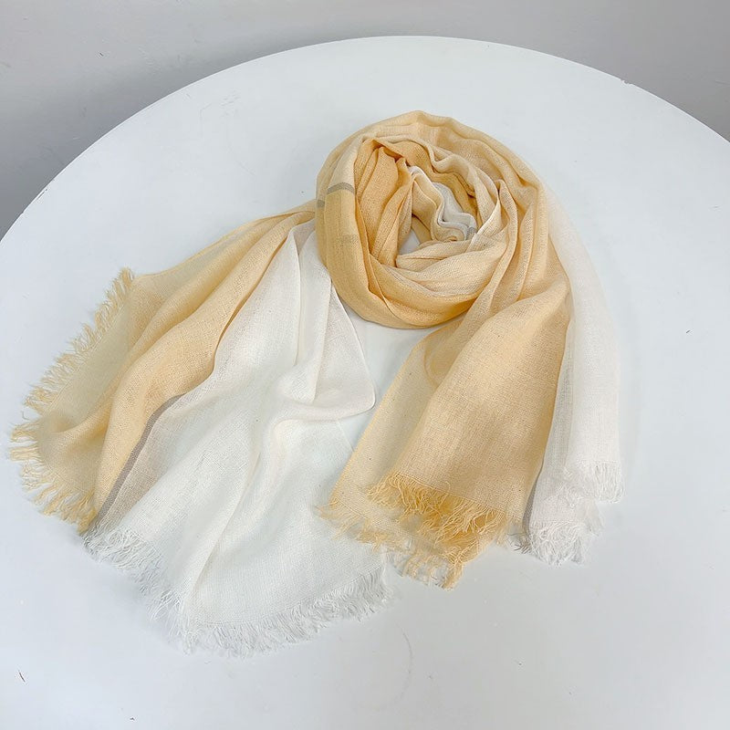 Beige and white scarf on a white surface