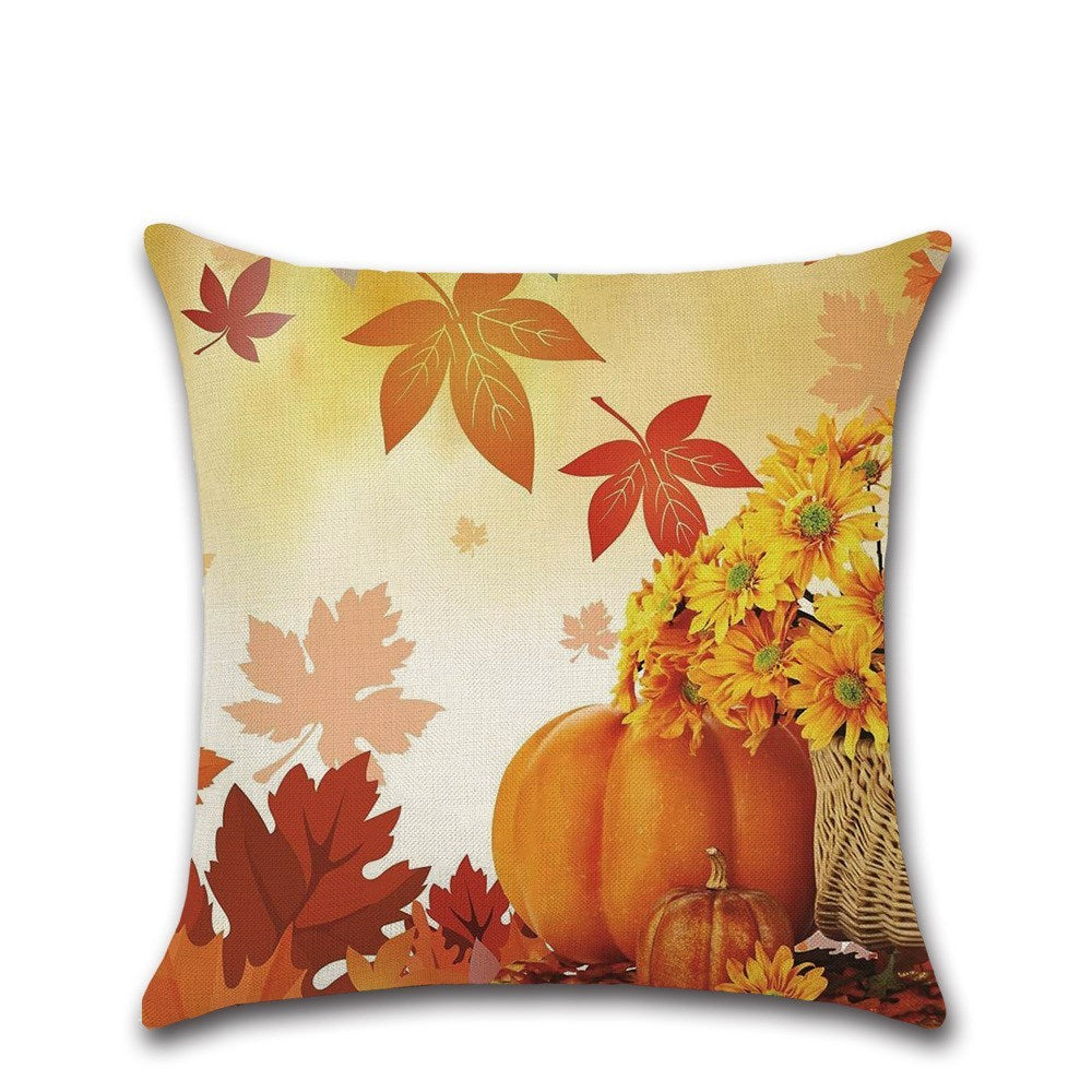 Decorative pillow with autumn design featuring pumpkins, leaves, and flowers on a white background.