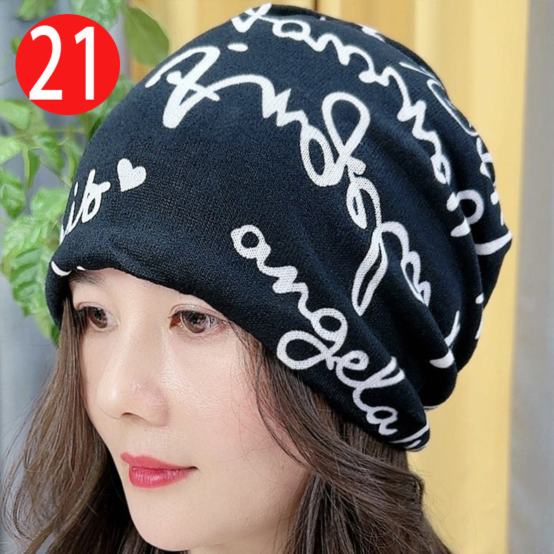 Black beanie with white text worn by a person, with a blurred background