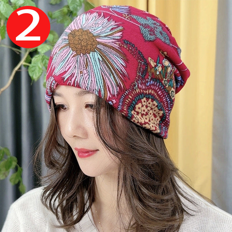 Woman wearing a colorful patterned headscarf with a plant and yellow curtain in the background