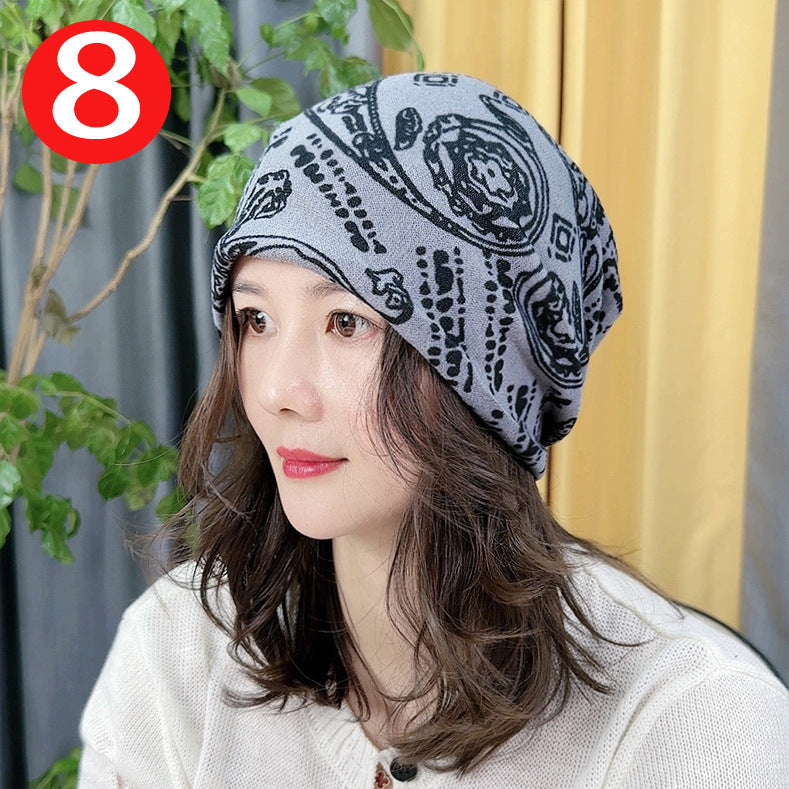Woman wearing a patterned headscarf with a plant and yellow curtain in the background