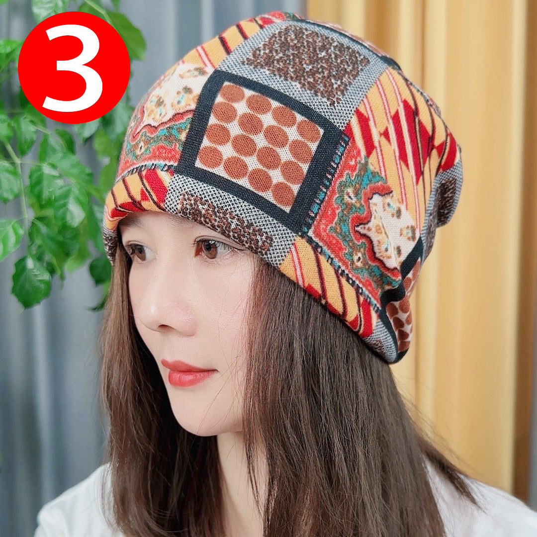 Woman wearing a colorful patterned headscarf with a plant and curtain in the background
