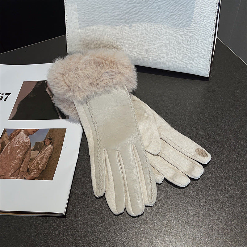 White gloves with fur cuff on a dark surface