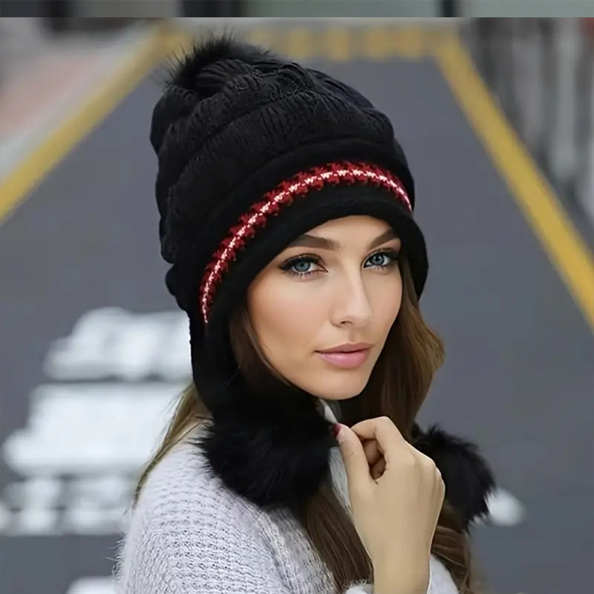 Woman wearing a black knit beanie with a red LED strip and fur trim.