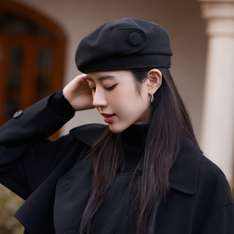 Woman wearing a black beret and coat outdoors