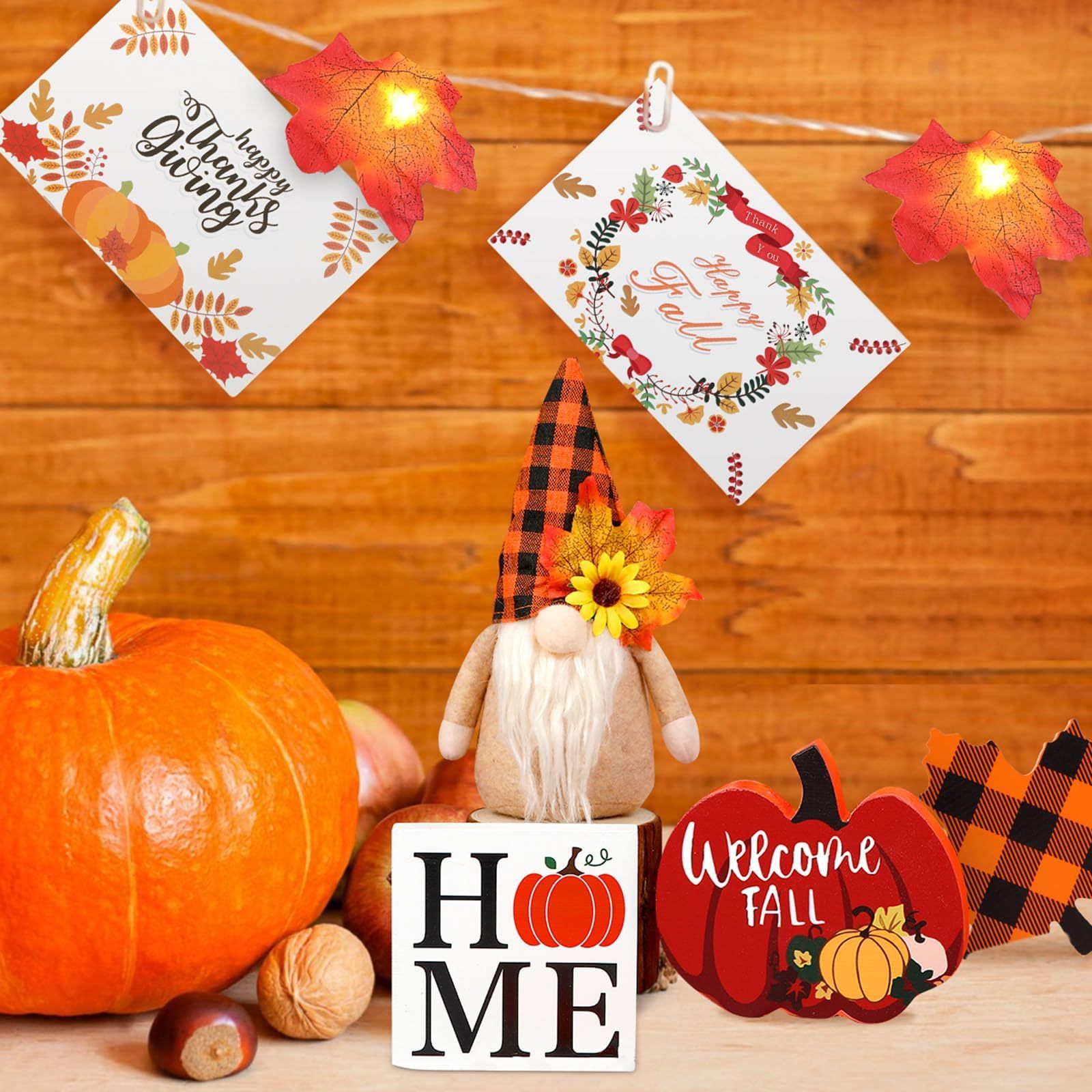 Autumn-themed decorations including a pumpkin, gnome, and signs on a wooden background.
