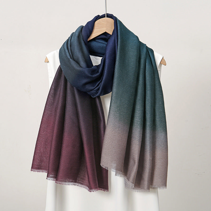 Two scarves with gradient colors on hangers against a white background