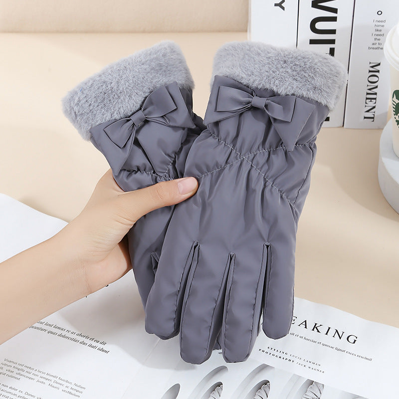 Gray gloves with bows held by a hand on a magazine background
